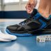 Close-up of a foot stepping into a basketball sneaker with a measuring tape and socks nearby, shot in an indoor court setting.